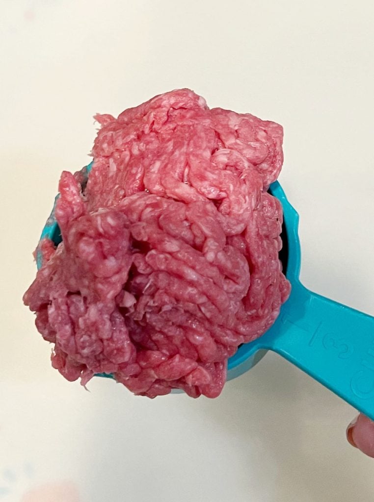 raw ground beef in ⅓ measuring cup