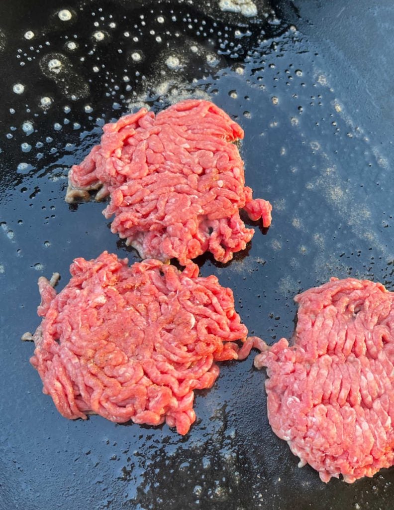 smashed ground beef patties on blackstone griddle