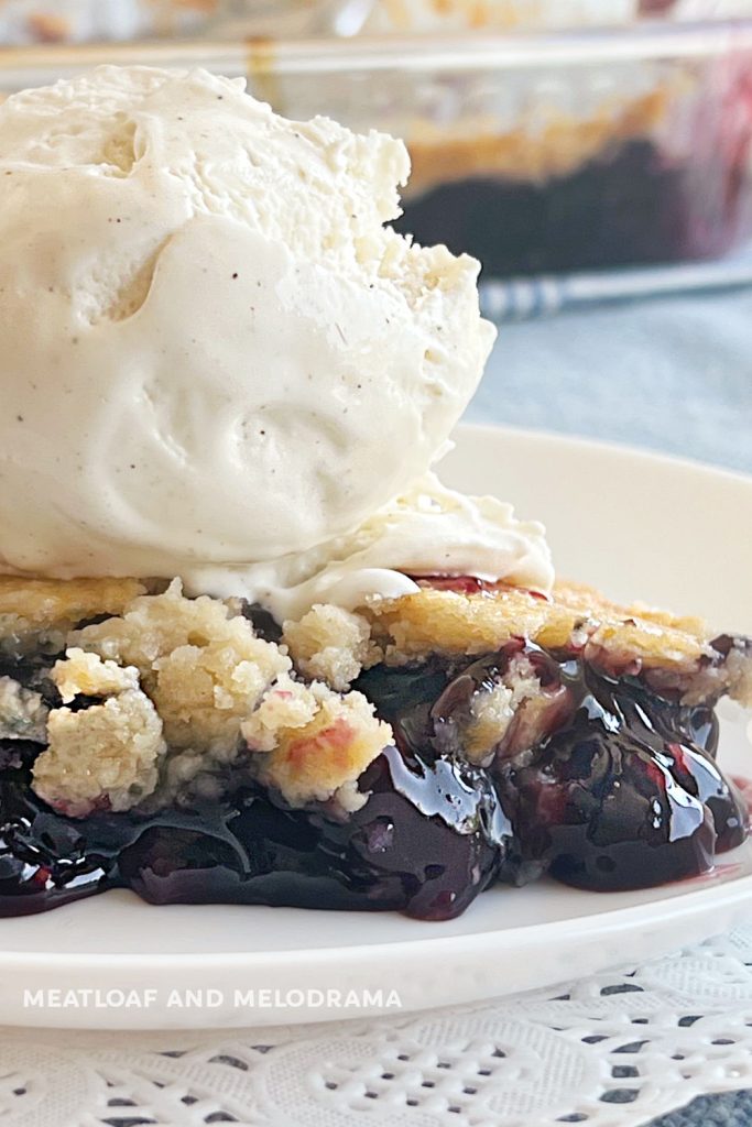 close up of dump cake with blueberry pie filling and ice cream on top