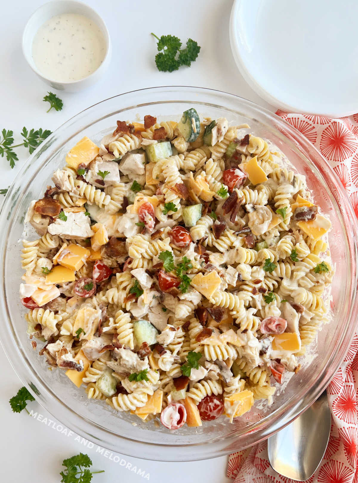 bowl of chicken bacon ranch pasta salad with cheese and parsley on table