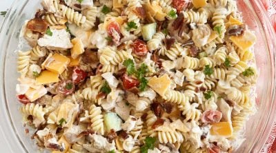 chicken bacon ranch pasta salad recipe in large glass bowl with parsley