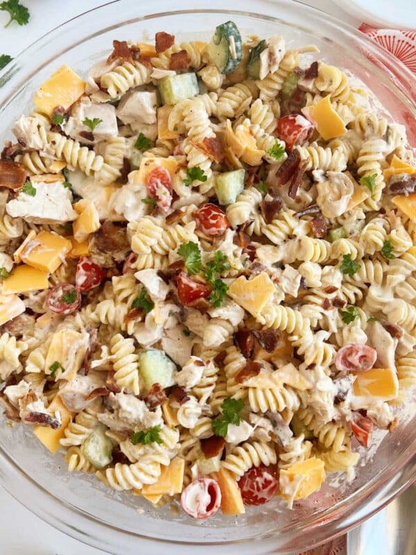 chicken bacon ranch pasta salad recipe in large glass bowl with parsley