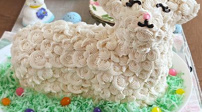 easter lamb cake decorated with buttercream frosting, colored coconut and jelly beans