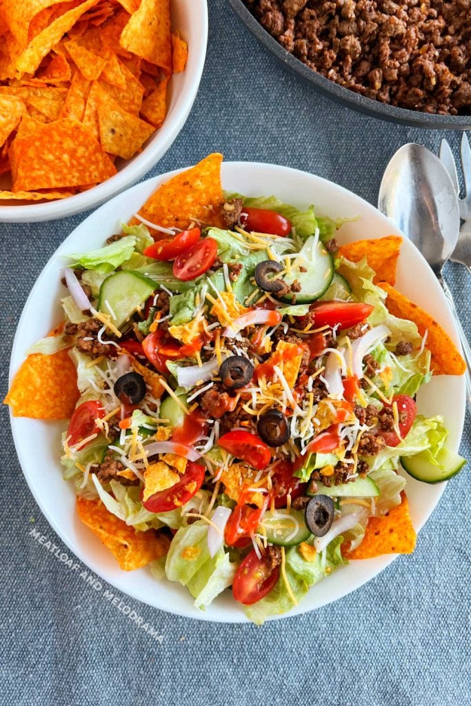 taco salad with catalina dressing and doritos and ground beef on the table
