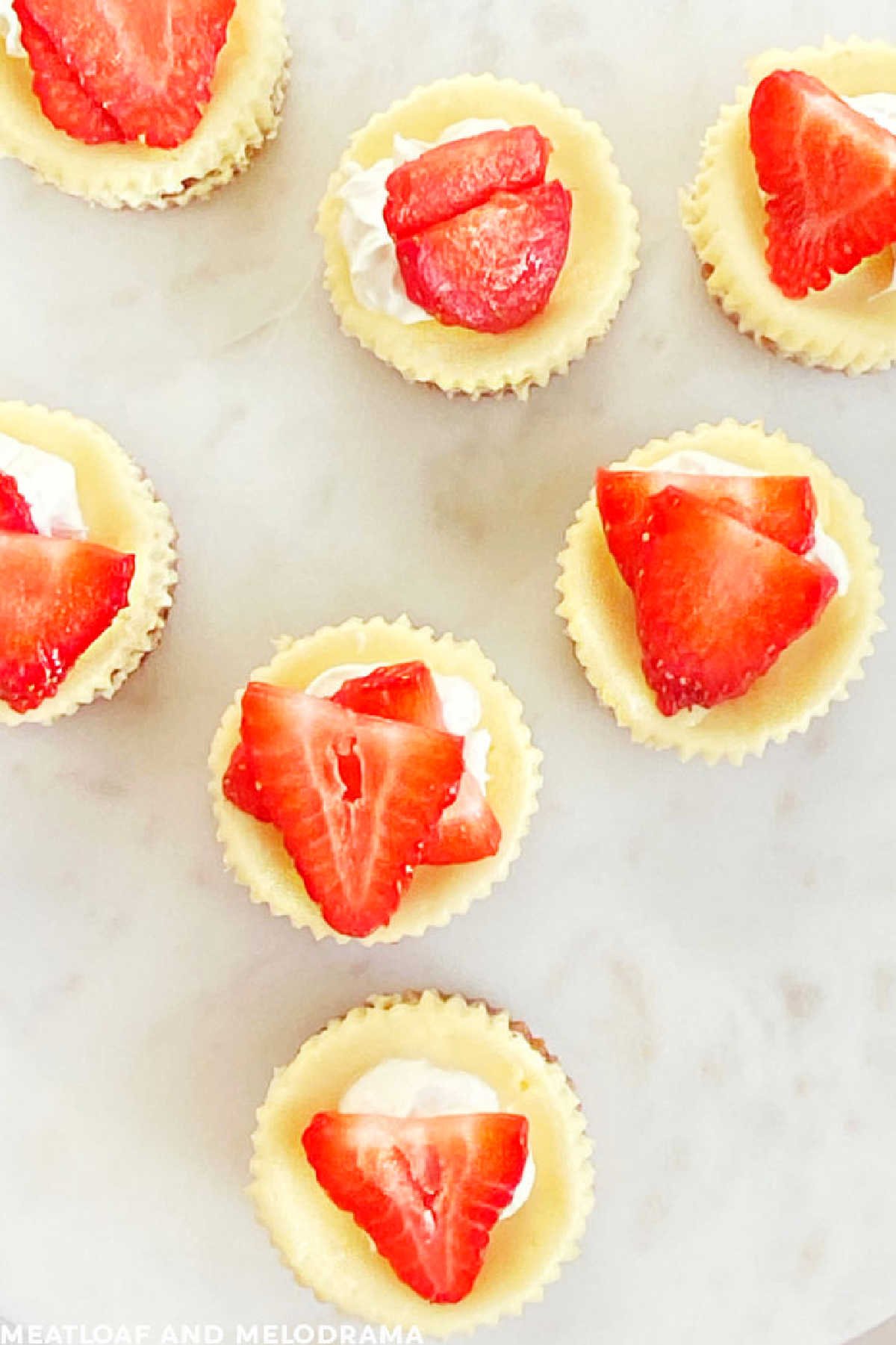 mini cheesecakes with graham cracker crust and fresh strawberry topping