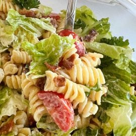 blt pasta salad with rotini pasta and bacon and lettuce and tomatoes on a spoon