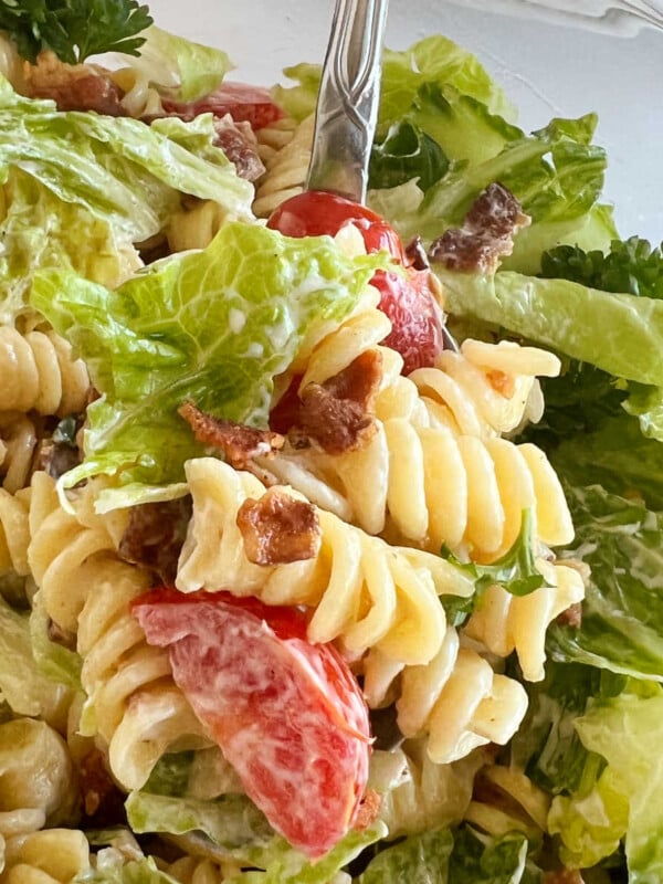 blt pasta salad with rotini pasta and bacon and lettuce and tomatoes on a spoon