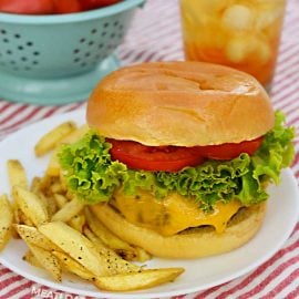 air fryer hamburger with cheese on a plate with french fries