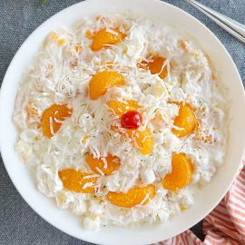 ambrosia fruit salad recipe with sour cream and mandarin oranges in white serving bowl