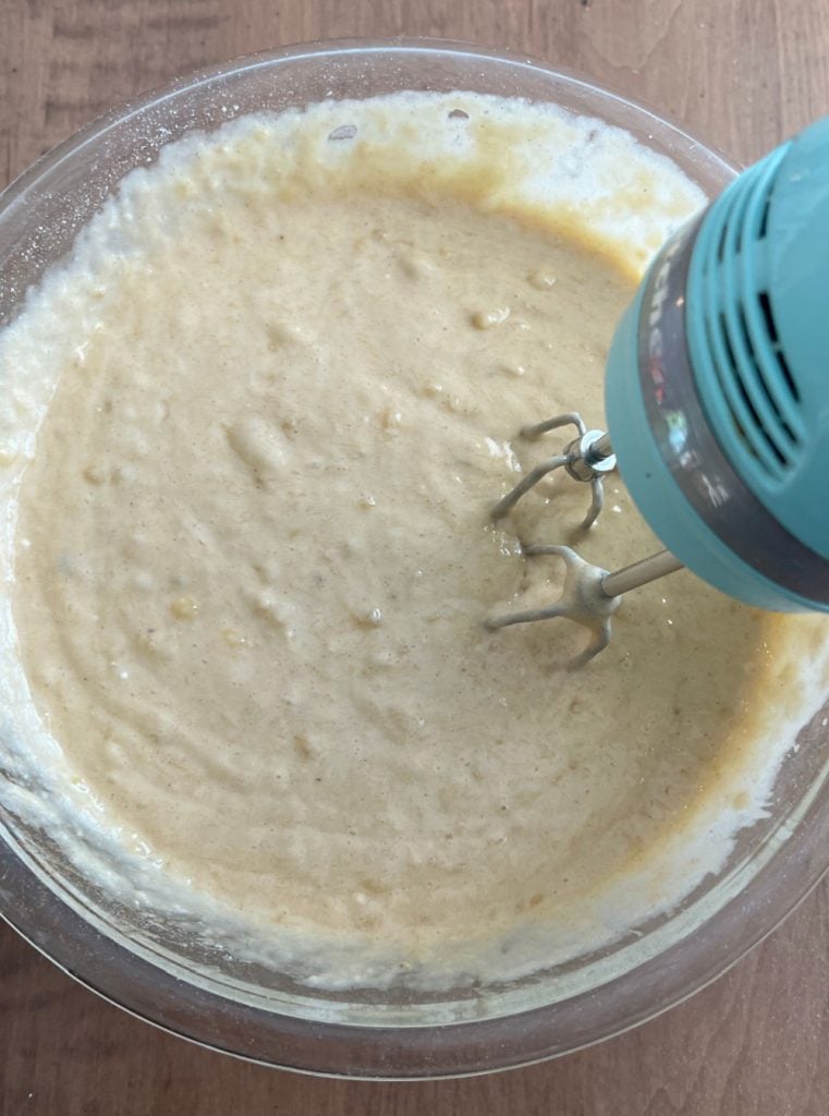 mix banana bread ingredients with hand mixer in mixing bowl