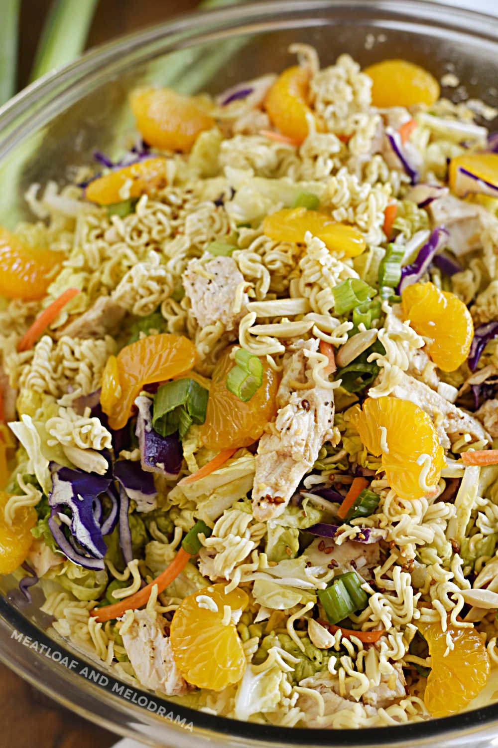 chinese ramen chicken salad with crunchy ramen noodles, mandarin oranges and napa cabbage in serving bowl