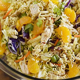 chinese ramen chicken salad with crunchy ramen noodles, napa cabbage and mandarin oranges in a serving bowl