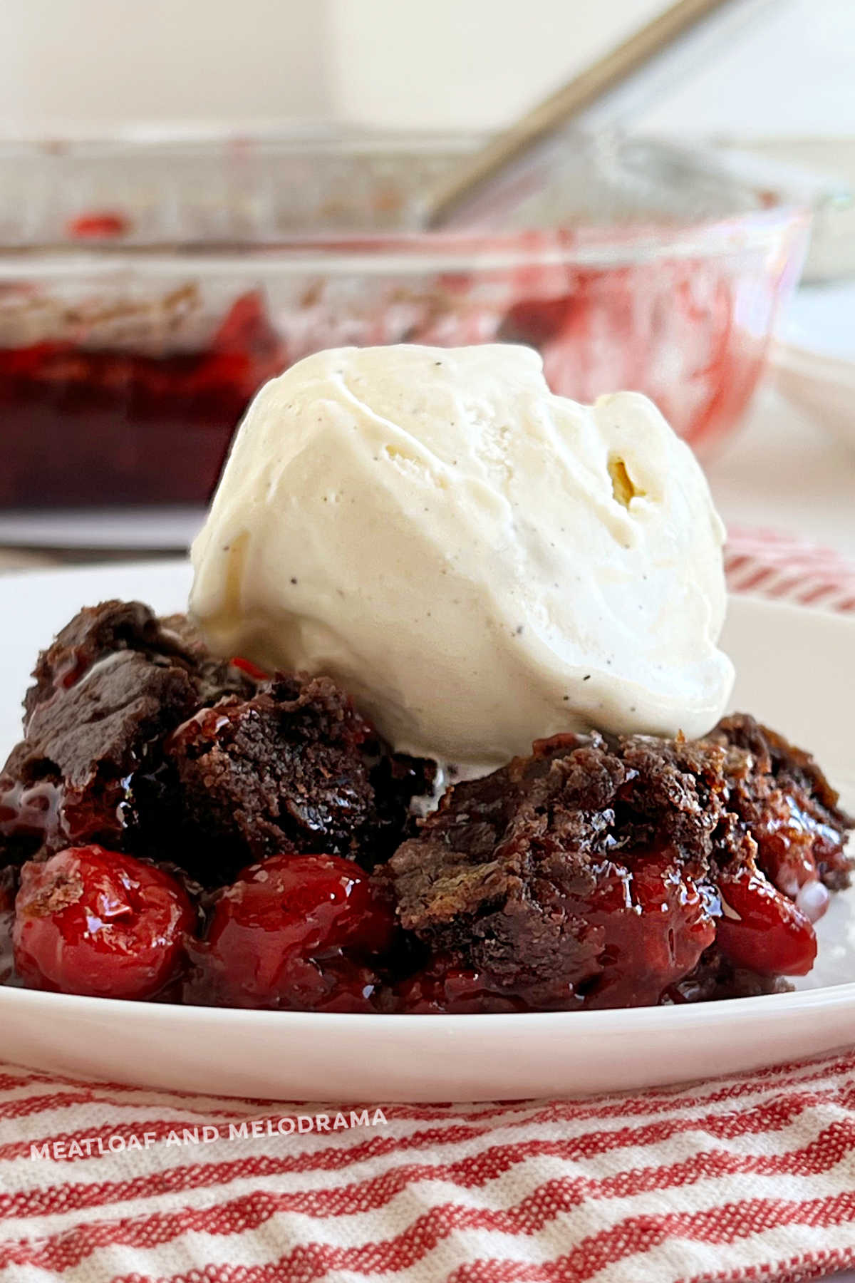 chocolate cherry dump cake with cherry pie filling topped with scoop of ice cream