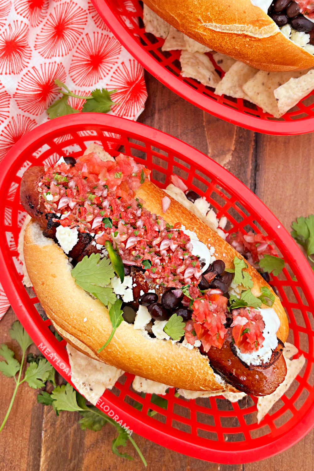sonoran hot dogs with bacon, pico, cotija cheese, beans and cilantro on the table