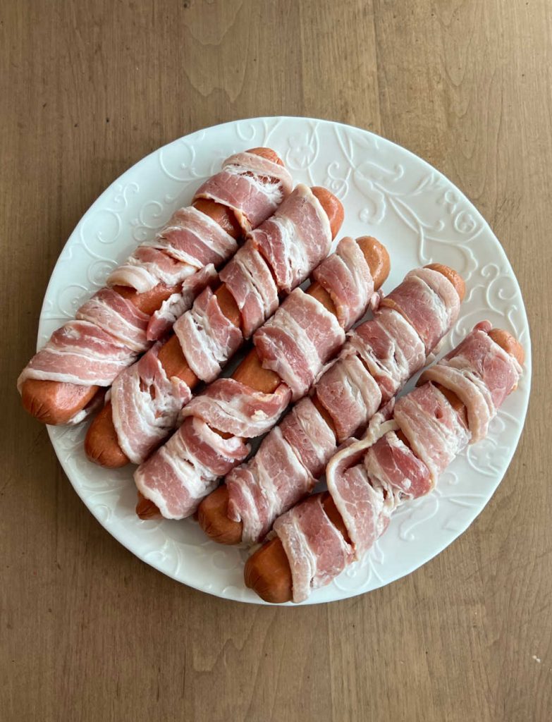 bacon wrapped hot dogs on table