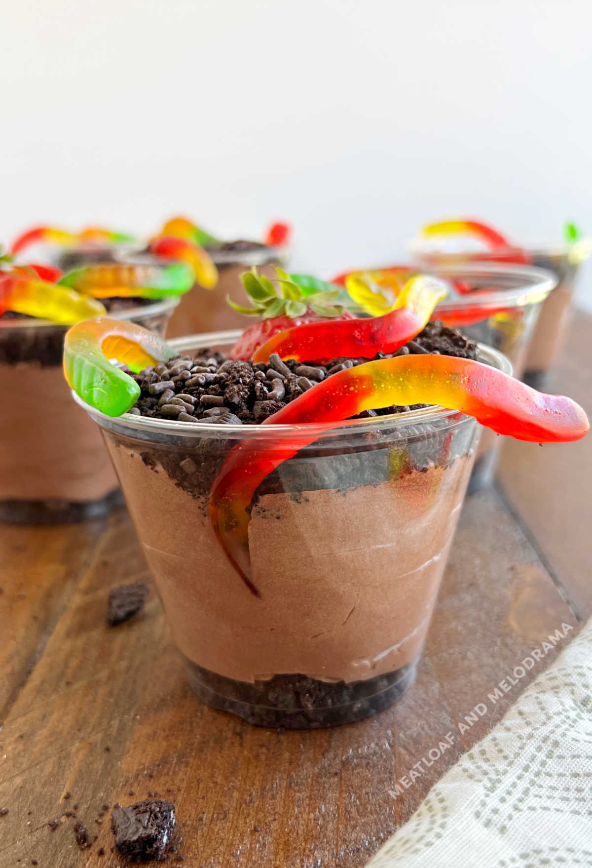 side view of layered dirt pie cups with gummy worms