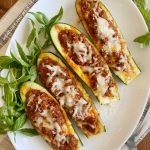 low carb stuffed zucchini boats with italian sausage and cheese on platter