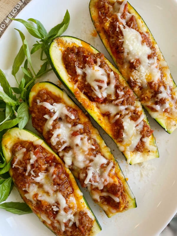 low carb stuffed zucchini boats with italian sausage and cheese on platter