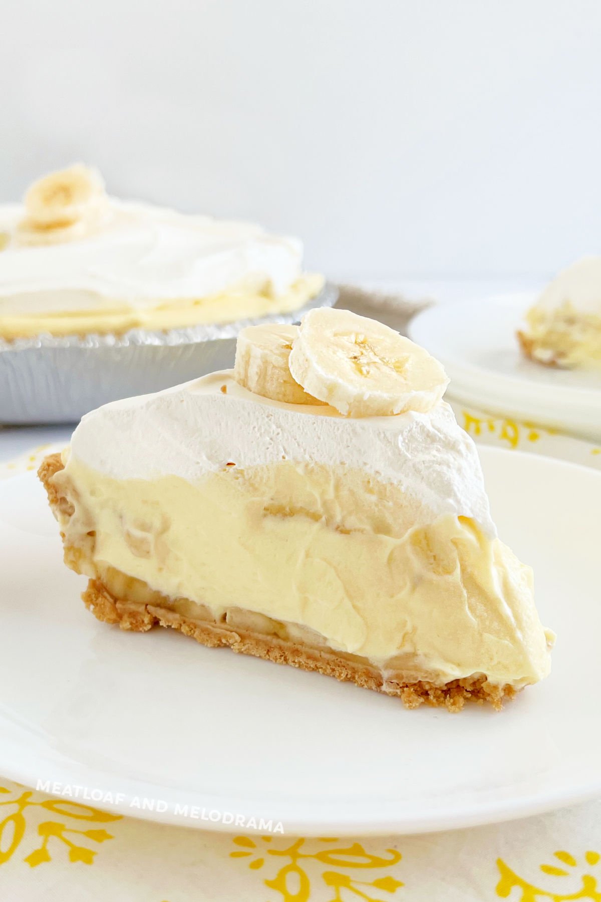 slice of no bake banana pudding pie in graham cracker crust with cool whip