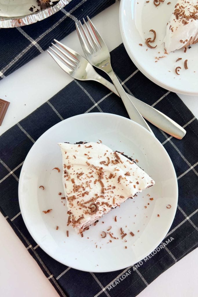 slice of no bake chocolate pie with cool whip and chocolate shavings on plate