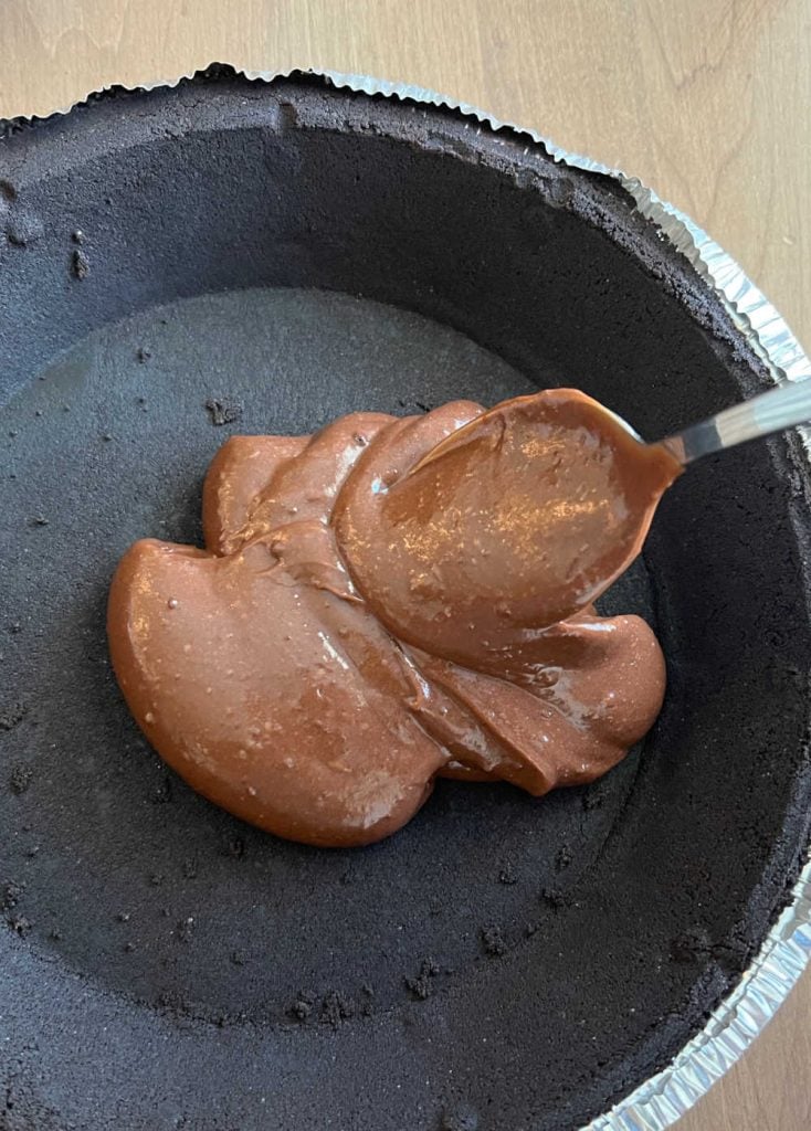 spoon instant chocolate pudding into oreo cookie pie crust