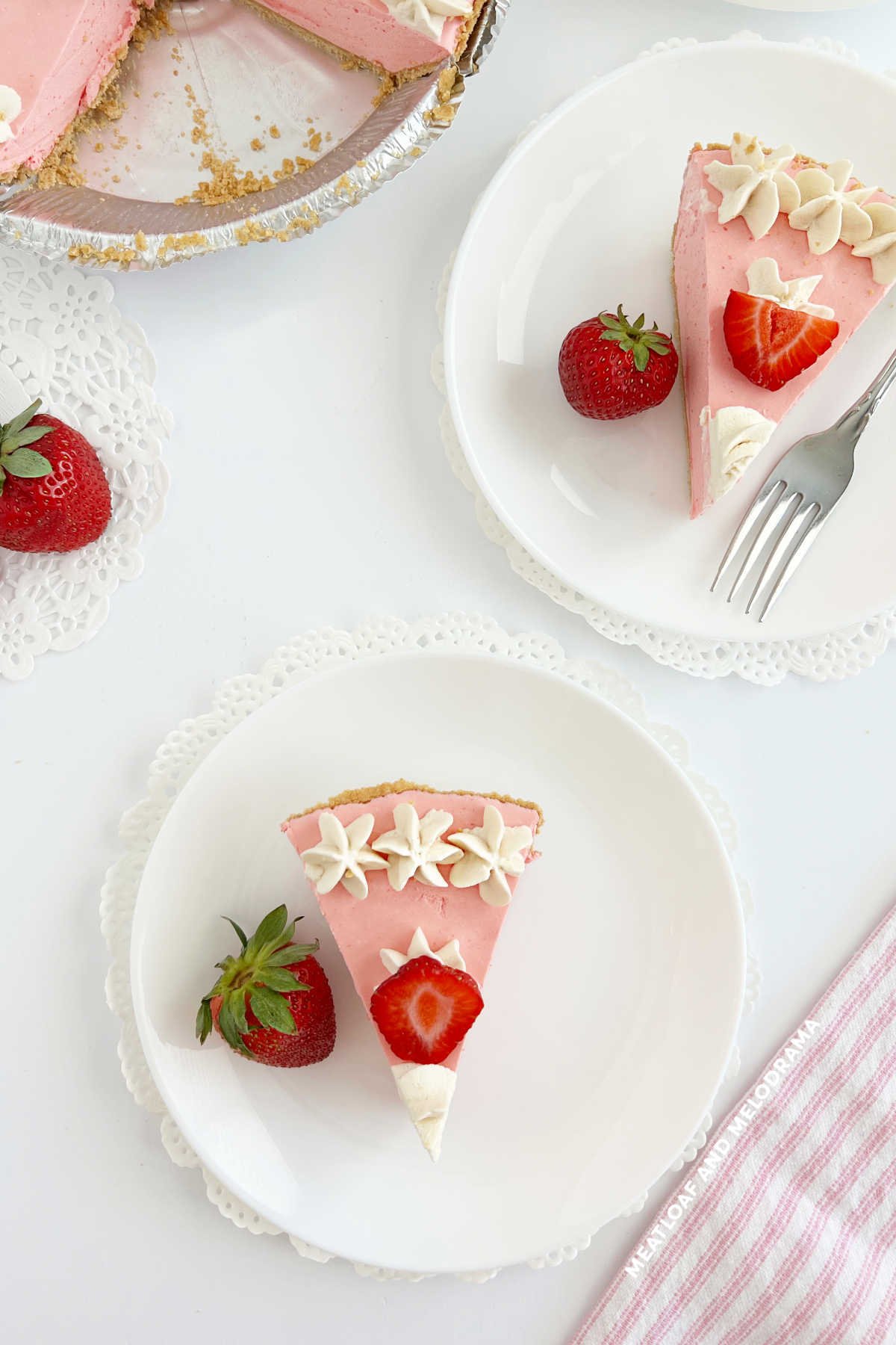 slices of strawberry jello cool whip pie with strawberries on table