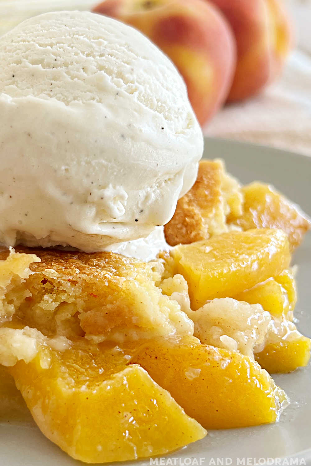 close up of peach dump cake with ice cream on top