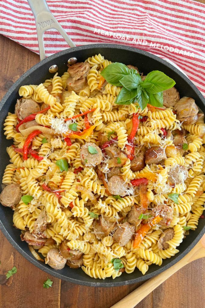 Italian sausage and peppers with rotini pasta in skillet