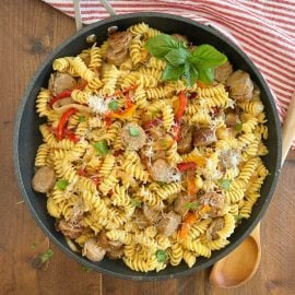 italian sausage and peppers pasta with onions in large skillet with basil