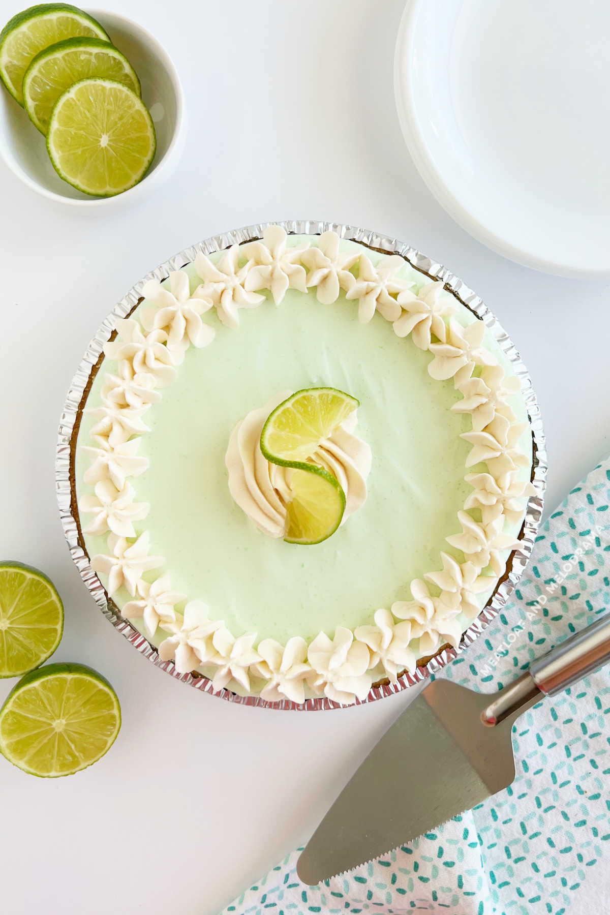 no bake key lime pie with whipped cream and lime slice on table