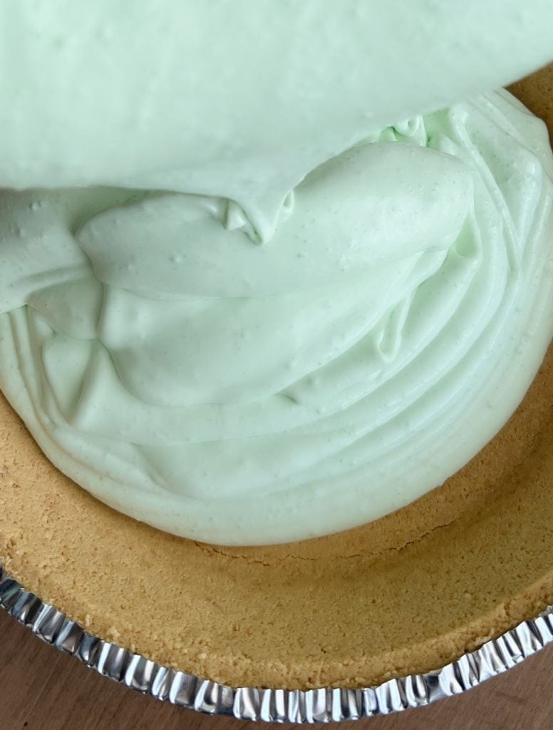 pour lime jello cool whip pie filling into pie crust