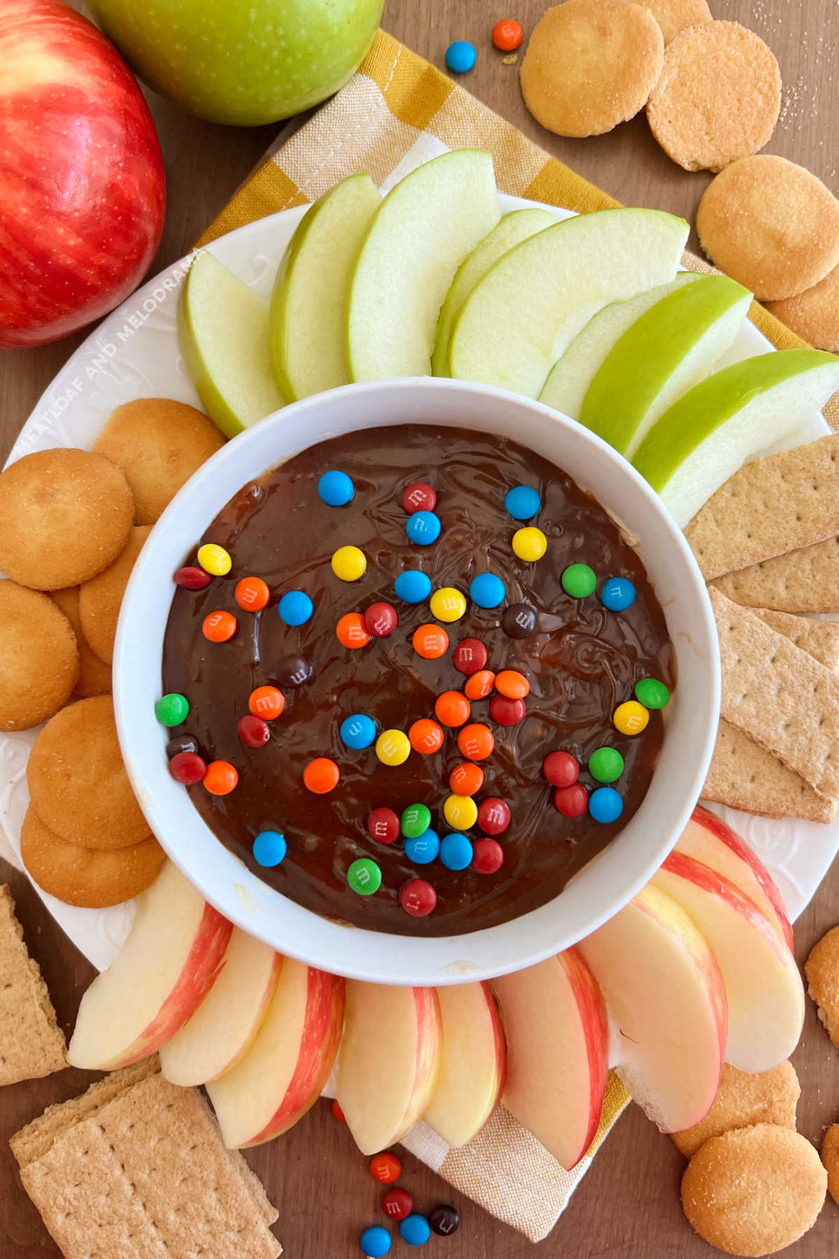 caramel apple dip in serving bowl with fresh apple slices, graham crackers and vanilla wafers