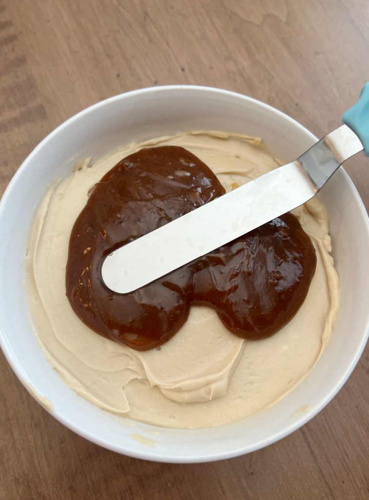 spread caramel sauce over cream cheese mixture in bowl