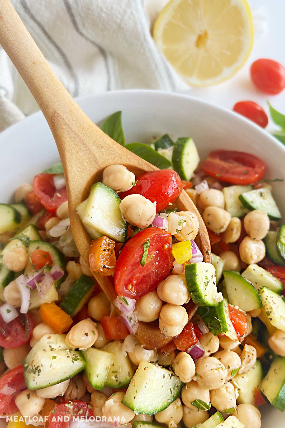 chickpea salad on wooden spoon over serving bowl