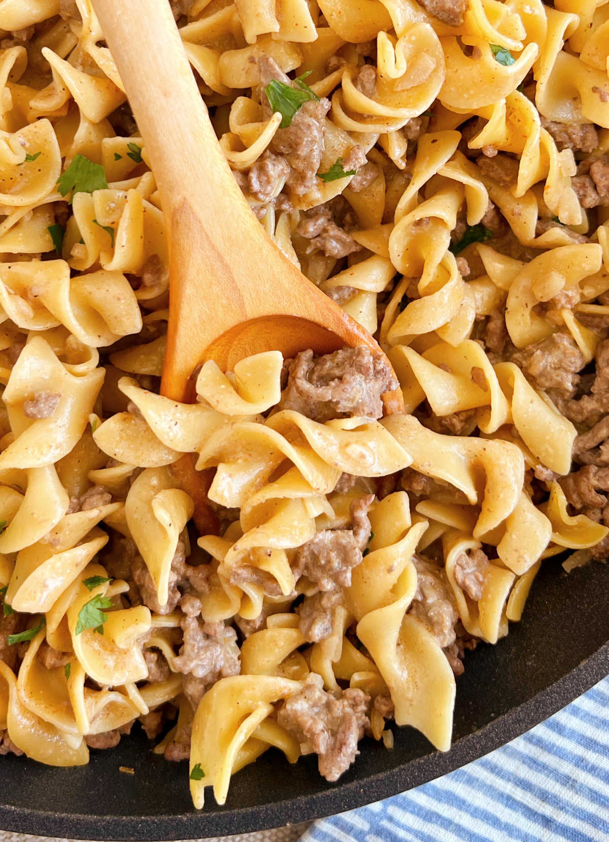 homemade hamburger helper stroganoff on wooden spoon in skillet