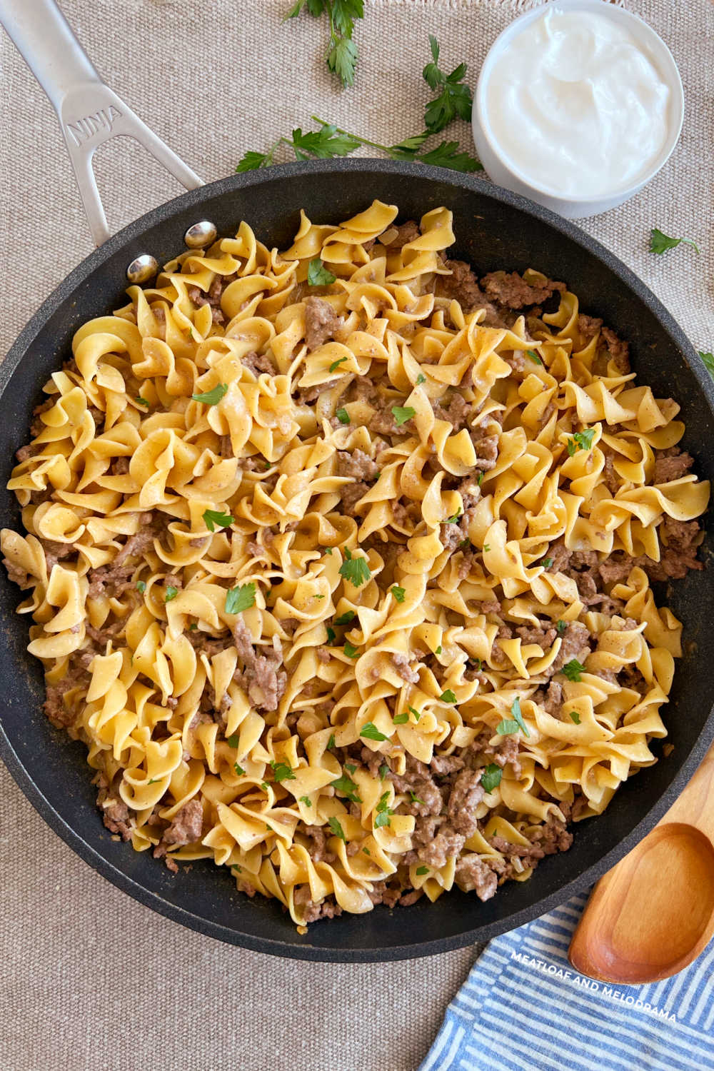 ground beef stroganoff in skillet with sour cream and parsley