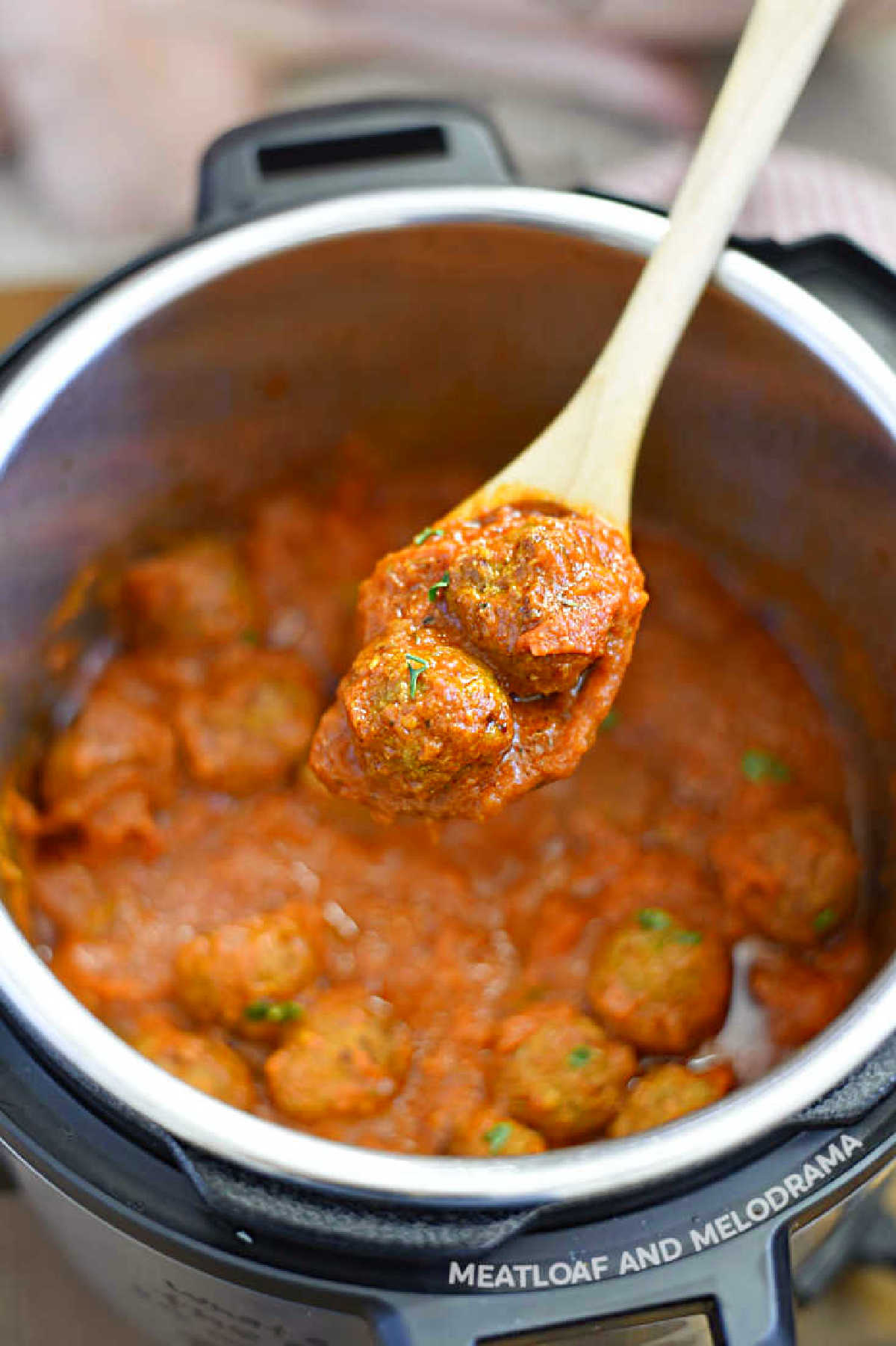 instant pot meatballs in pasta sauce on wooden spoon