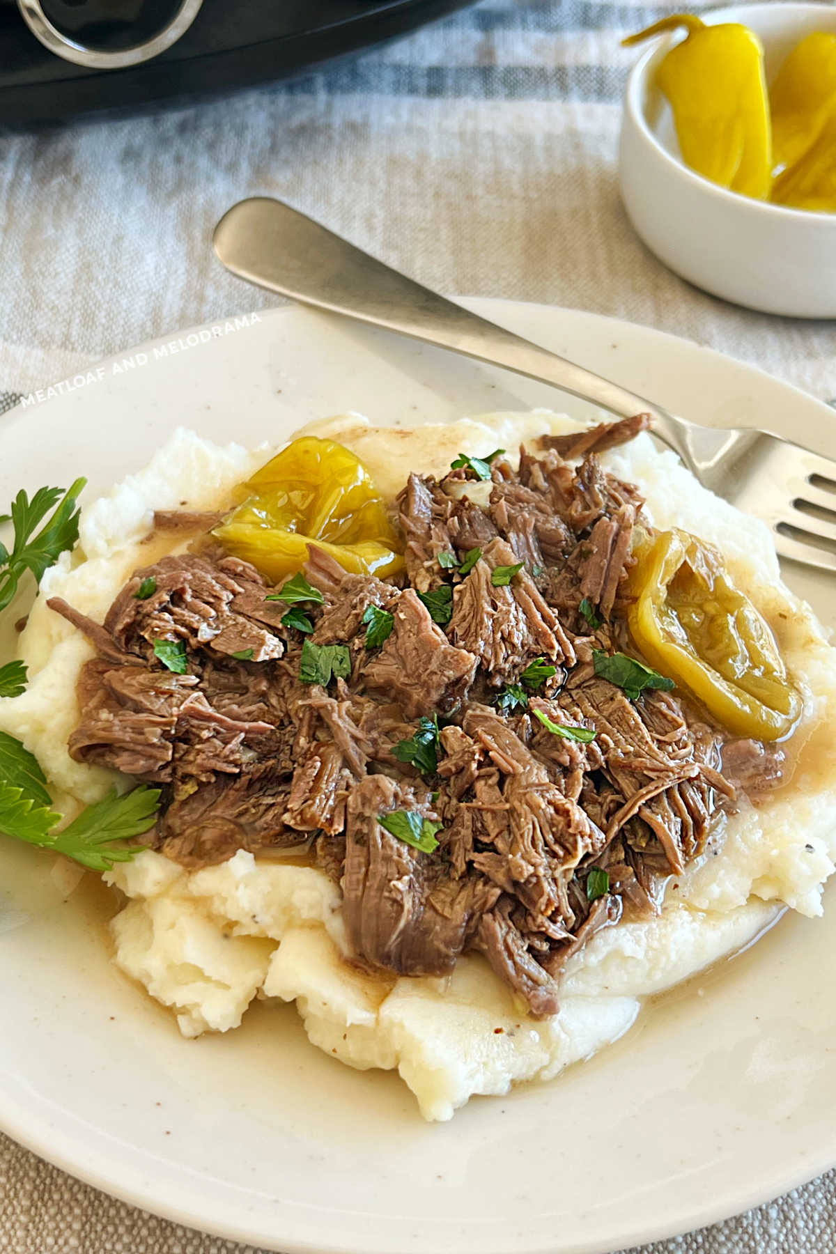 shredded mississippi pot roast and peperoncini peppers over mashed potatoes