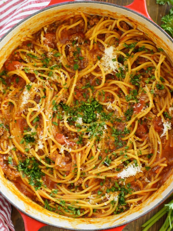 one-pot spaghetti and meat sauce with parsley in red Le Creuset Dutch oven