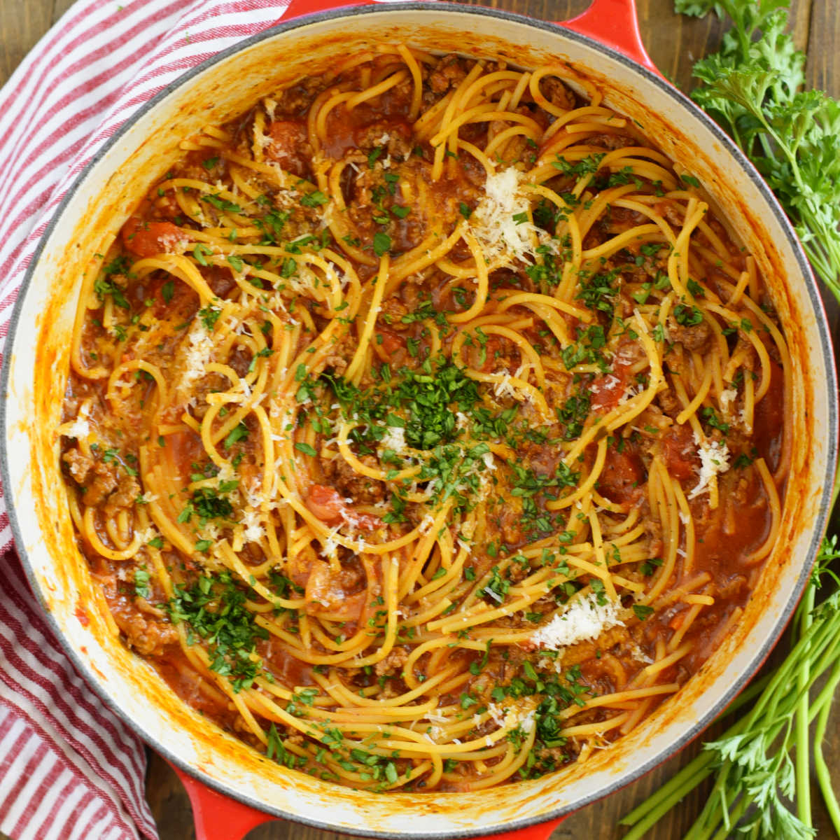 one-pot spaghetti and meat sauce with parsley in red Le Creuset Dutch oven