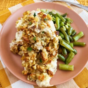baked chicken topped with stove top stuffing and green beans on plate
