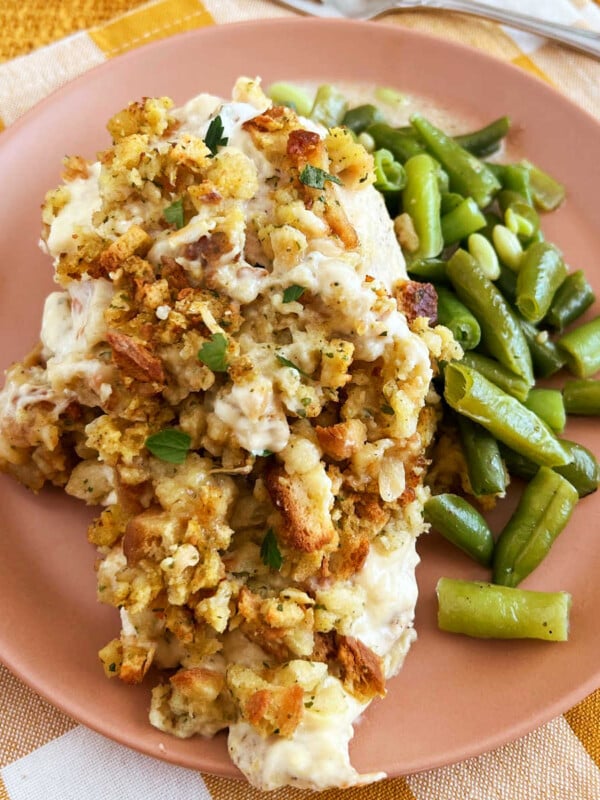 baked chicken topped with stove top stuffing and green beans on plate