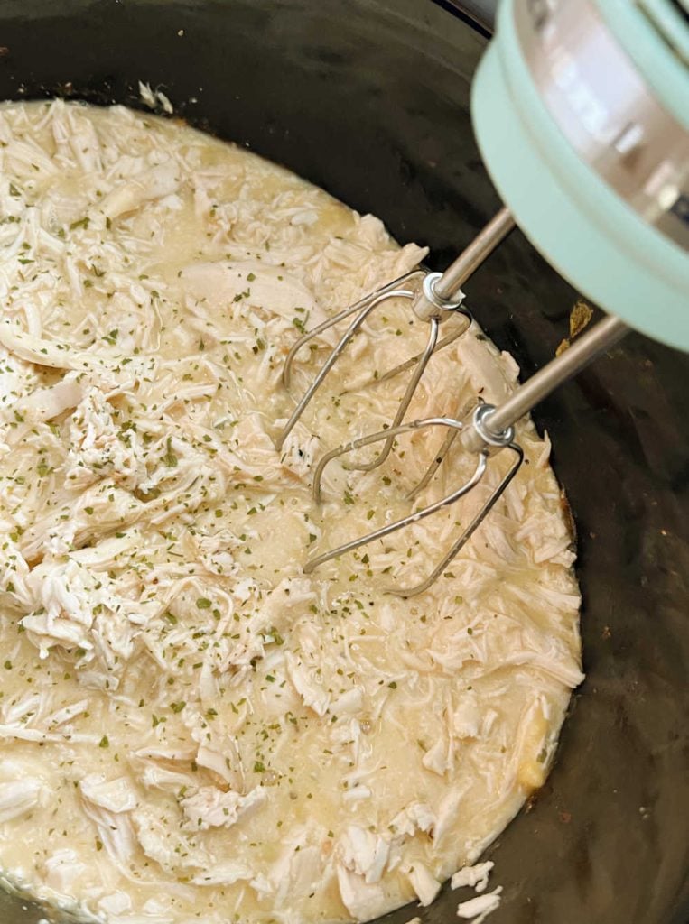 shred chicken with hand mixer in slow cooker