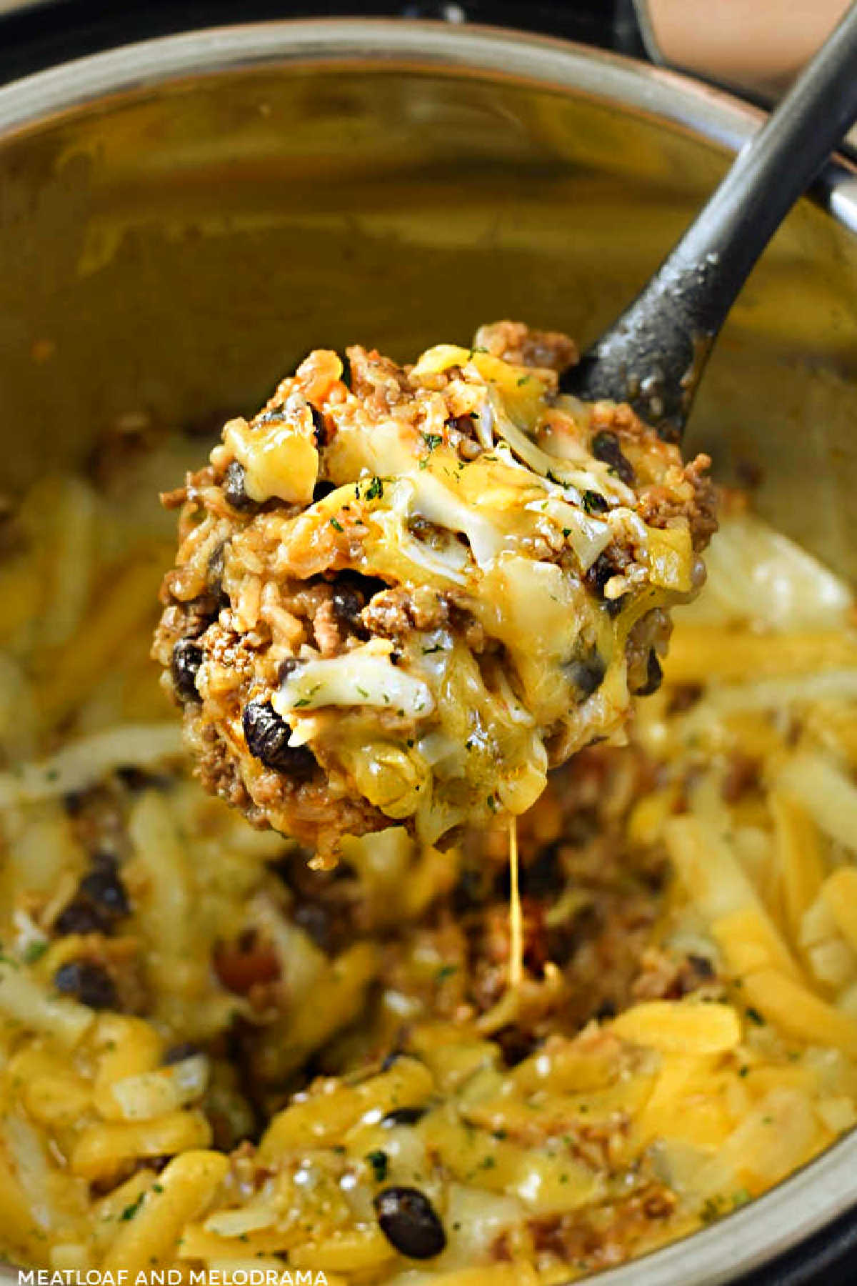 instant pot Mexican beef and rice with cheese on serving spoon