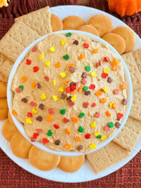 pumpkin pie dip with fall sprinkles and cookies in a white bowl