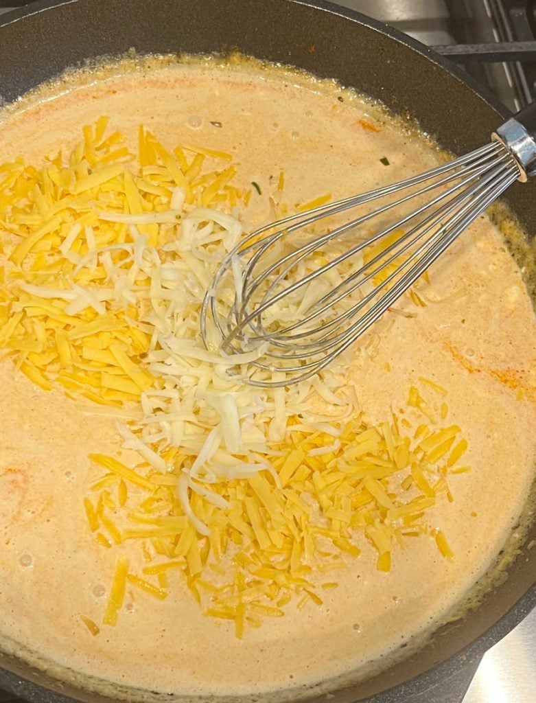 whisk pepper jack cheese and cheddar cheese in queso in skillet