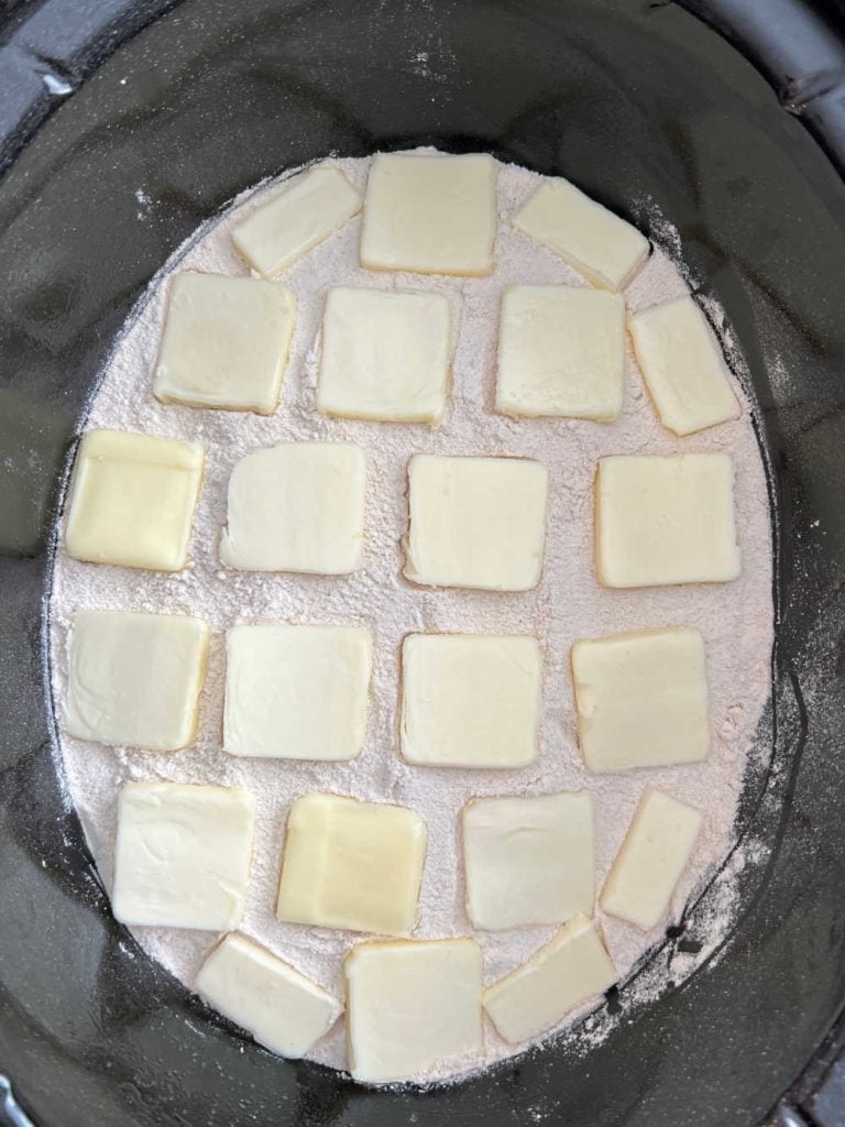 pats of butter on cake mix in crock pot