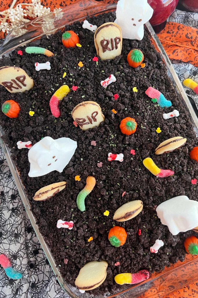 halloween graveyard cake with milano gravestones and candy in pan