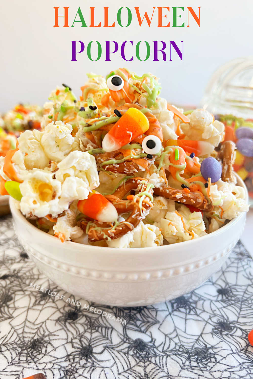 Monster Munch Halloween Popcorn recipe with white chocolate, pretzels, candy coating and candy is a fun treat for a Halloween party. Everyone loves this sweet and salty Halloween snack mix. via @meamel