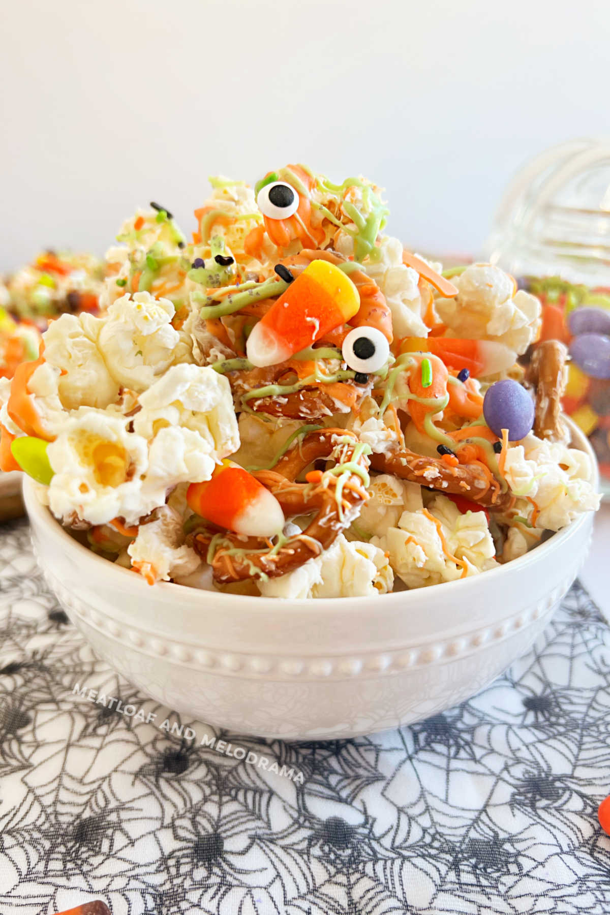 monster munch halloween popcorn mix with pretzels and candy in white bowl